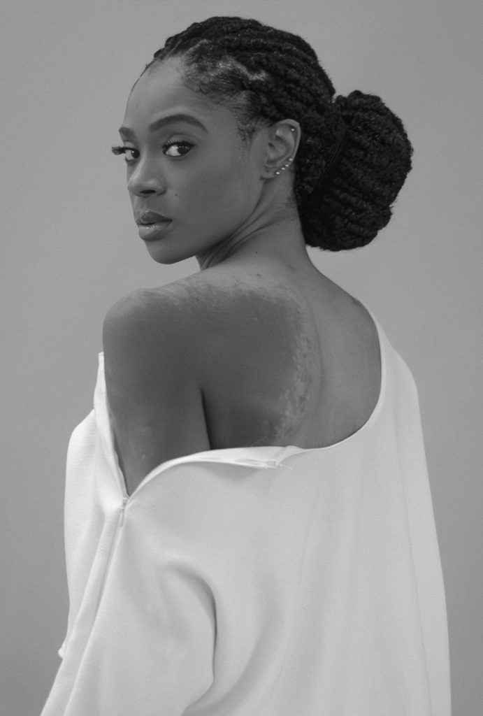 Portrait of a model in a sculptural white garment, highlighting texture, form, and silhouette.